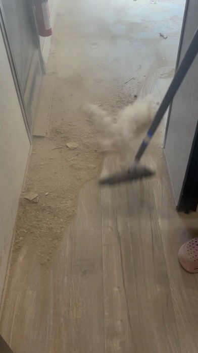 deyvin sweeping a dusty hallway floor